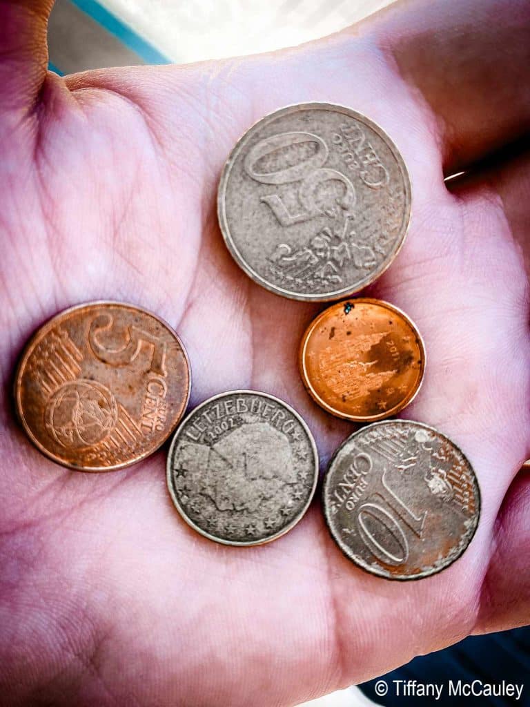 European coins held in a hand.